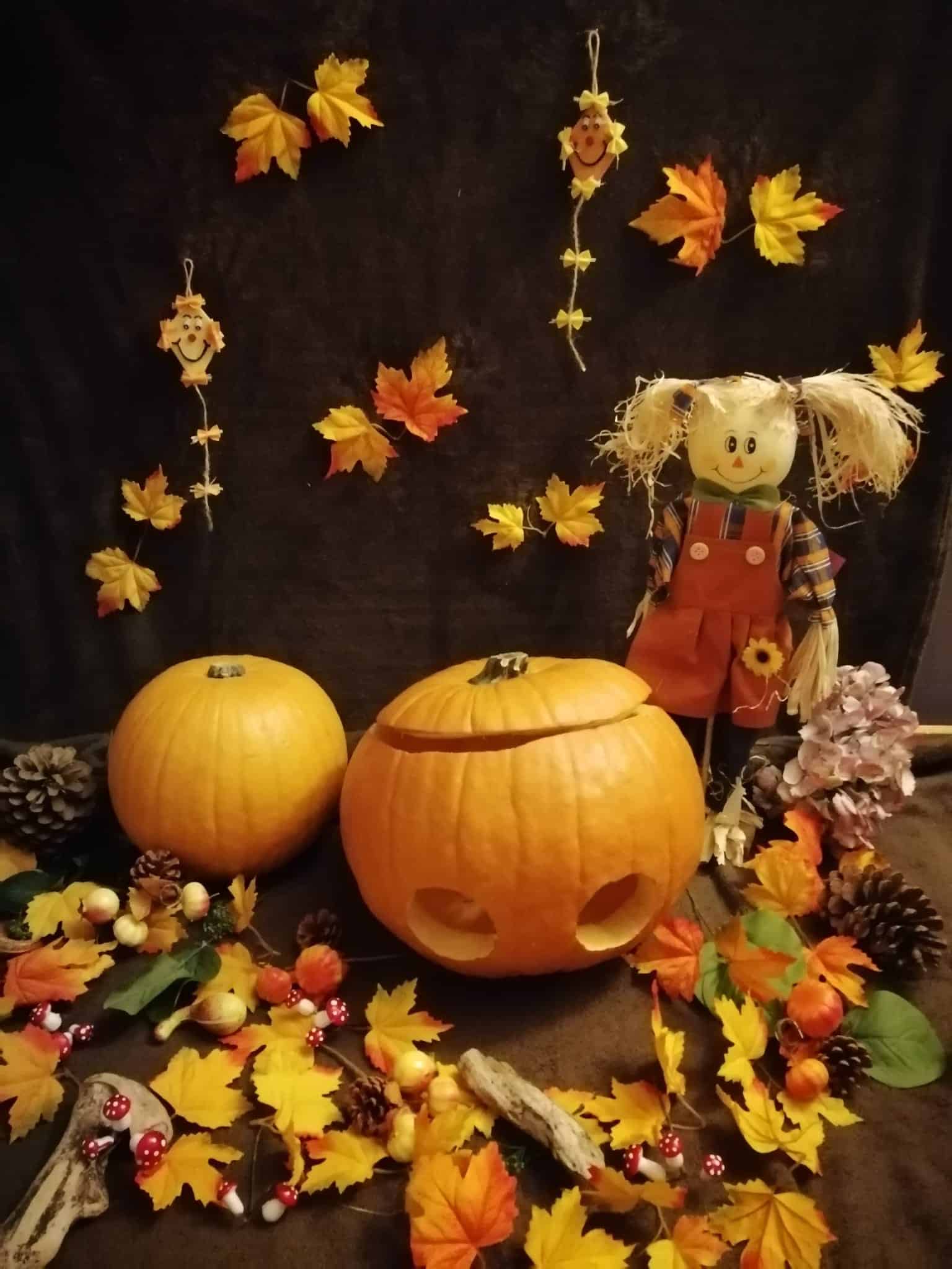 Décoration d'Halloween avec citrouilles, feuilles d'automne et épouvantail